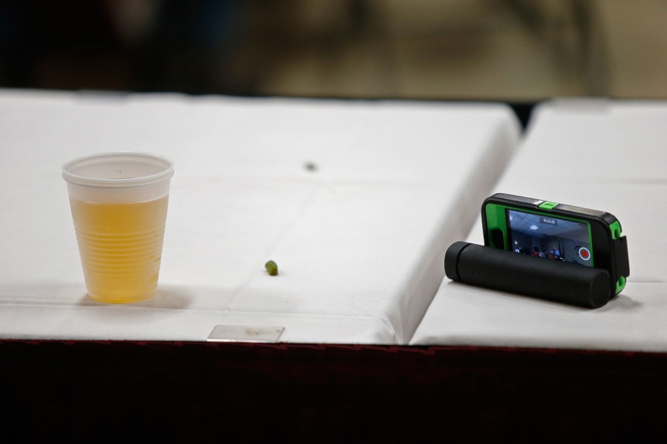 A beer and a cell phone recording a speech by Sen. Bernie Sanders (I-VT) sit on an unattended table at the Hawkeye Labor Council AFL-CIO Steak Fry in Cedar Rapids on Saturday, June 13, 2015. (Adam Wesley/The Gazette)