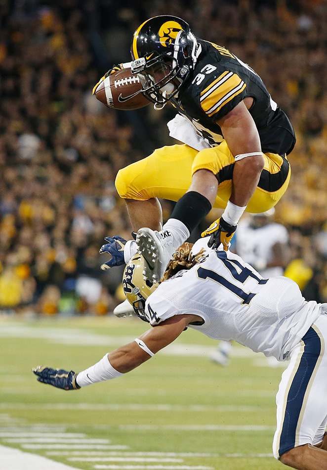 Iowa Hawkeyes running back Jordan Canzeri (33) hurdles Pittsburgh Panthers defensive back Avonte Maddox (14) on his way to a first down in the 4th quarter of a NCAA football game at Kinnick Stadium in Iowa City on Saturday, Sept. 19, 2015. (Adam Wesley/The Gazette)