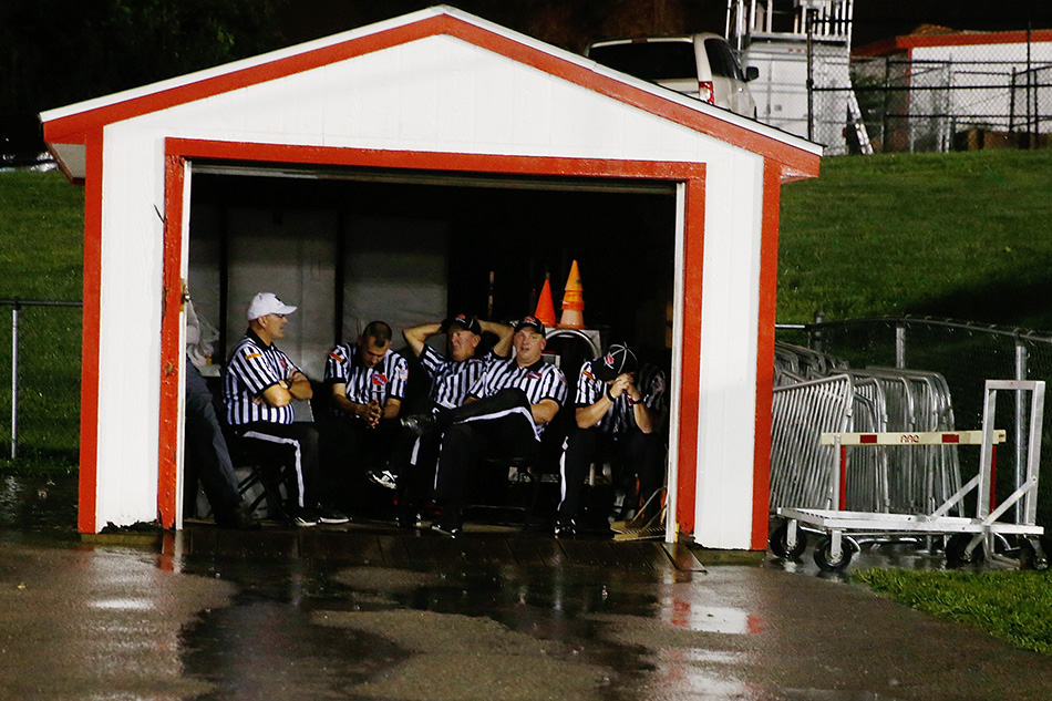 Referees take shelter from the rain during a lightning delay in the Iowa City High against Iowa City West class 4A high school football game at City High School in Iowa City on Friday, Sept. 18, 2015. (Adam Wesley/The Gazette)