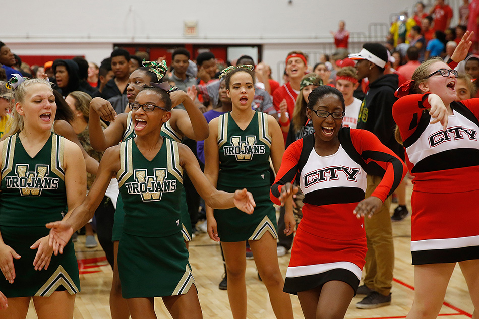 Cheerleaders from Iowa City High and Iowa City West dance in the gym during a lightning delay in a class 4A high school football game at City High School in Iowa City on Friday, Sept. 18, 2015. (Adam Wesley/The Gazette)