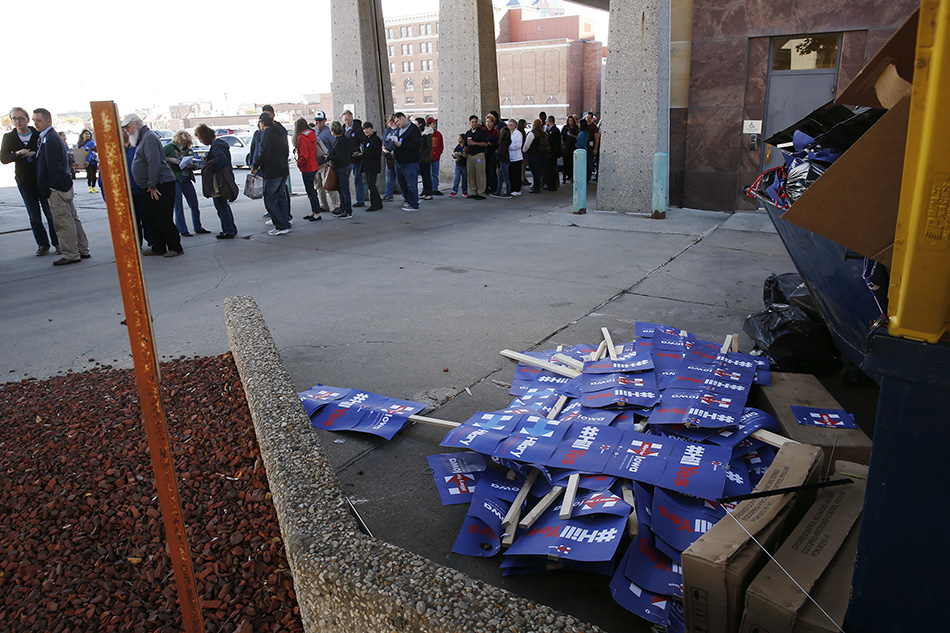 People line up for a Katy Perry concert near a pile of Hillary Clinton signs in Des Moines on Saturday, Oct. 24, 2015. (Adam Wesley/The Gazette)