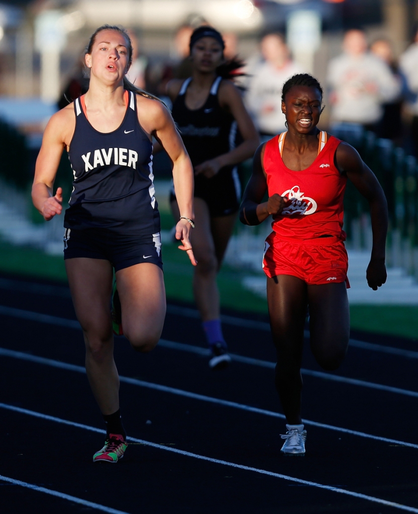Iowa City High's Fanta Traore runs ahead of Cedar Rapids Xavier's Carlie Jurgens in the 200-meter dash at a girls' high school track meet at West High School in Iowa City on Tuesday, March 31, 2015. (Adam Wesley/The Gazette)