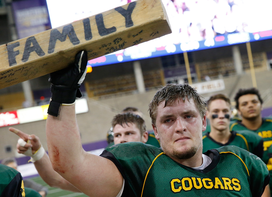 Cedar Rapids Kennedy's Dalles Jacobus (60) holds up a wooden board that reads "Family" as he walks off the field the high school football Class 4A state championship game against West Des Moines Dowling at the UNI-Dome in Cedar Falls on Monday, Nov. 23, 2015. (Adam Wesley/The Gazette)