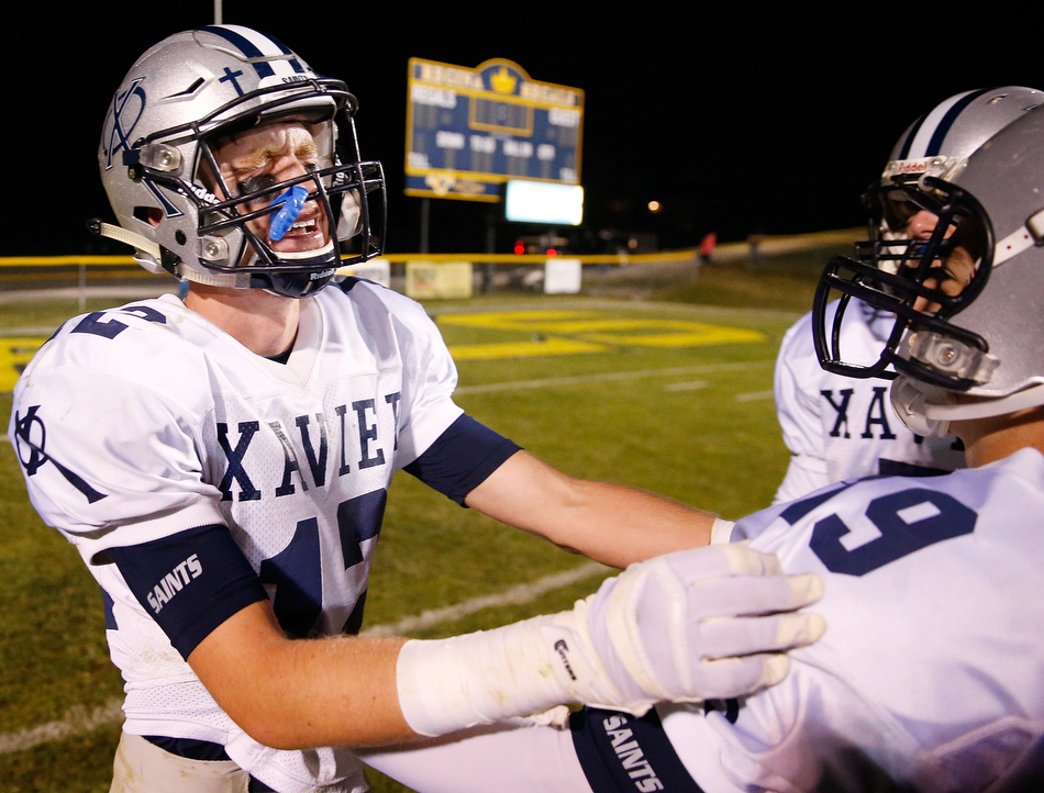 Cedar Rapids Xavier's Blake Whitten (12) sheds tears of joy as he celebrates with Dallas Klein (19) after the Saints defeated Iowa City Regina in a high school football game at Regina High School in Iowa City on Friday, Oct. 16, 2015. (Adam Wesley/The Gazette)